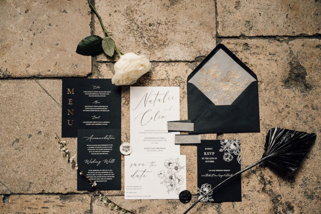 Black, white and gold wedding invitations set up