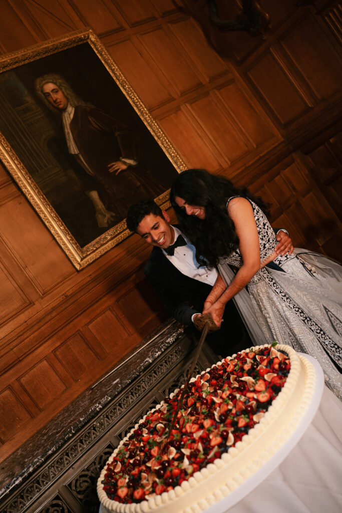 Bride and Groom, cake cutting with sword. Hannah Rose Weddings